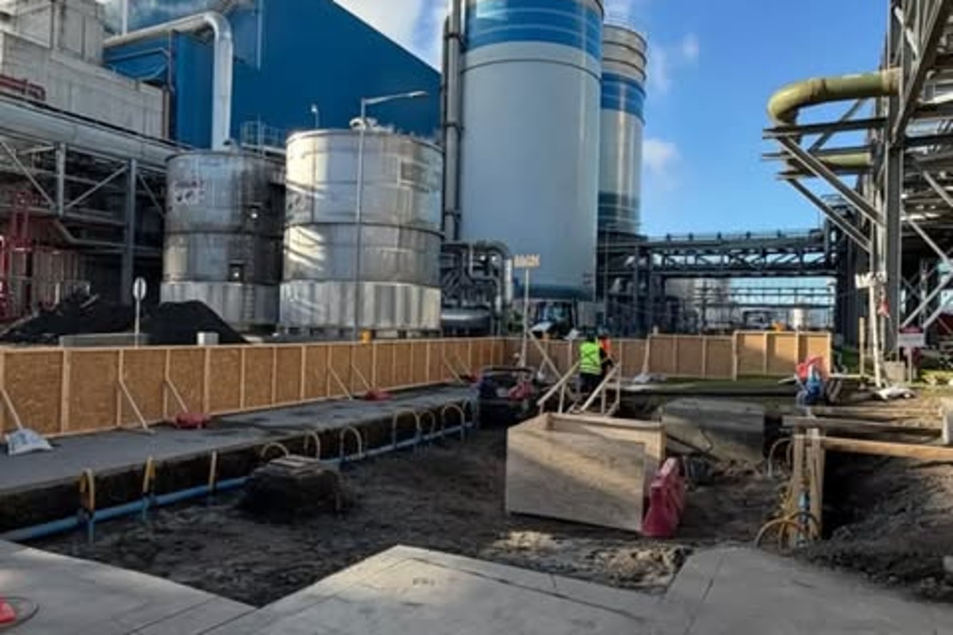 Planta industrial con silos y grúas al anochecer